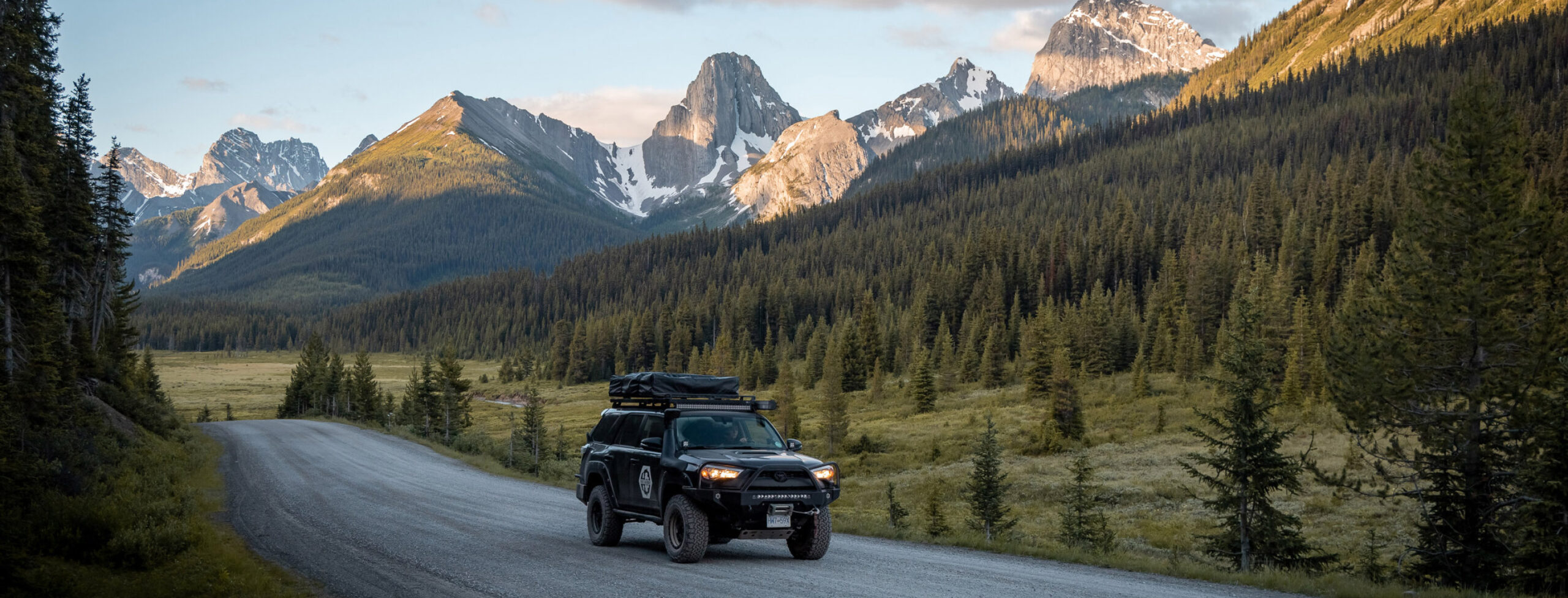 a guy driving toyoto car in beautifical canadian scenes