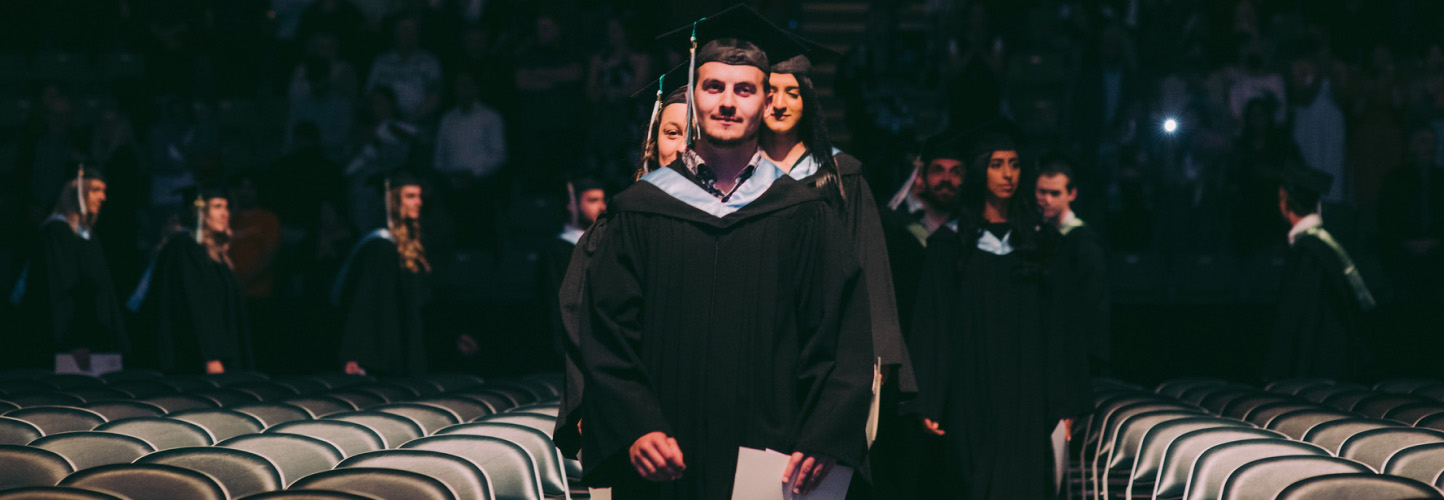 a guy walking to get his scholarship and has smile on his face